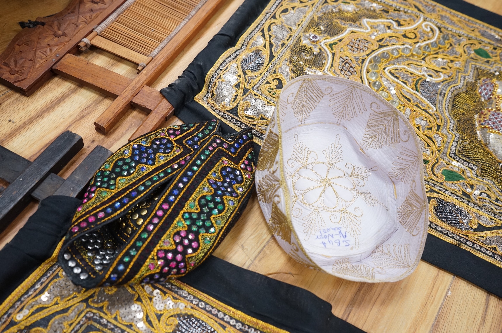 A quantity of mostly 20th century Middle Eastern and Indian woven and printed textiles and a peacock feather fan (2 boxes).
